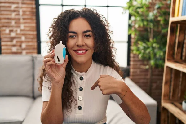 Young Hispanic Woman Using Glucose Meter Pointing Finger One Self — Stockfoto