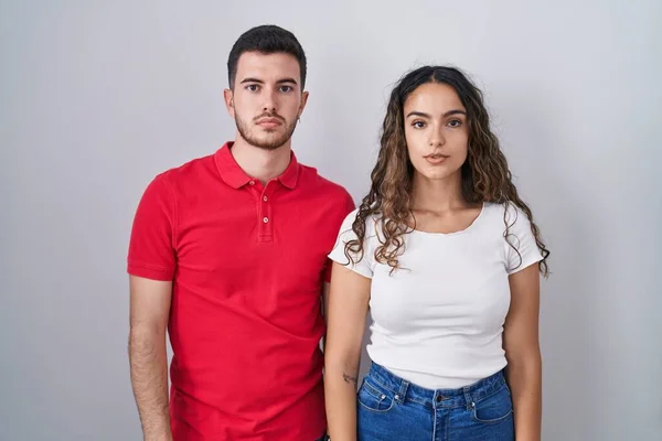 Young Hispanic Couple Standing Isolated Background Relaxed Serious Expression Face — Stockfoto