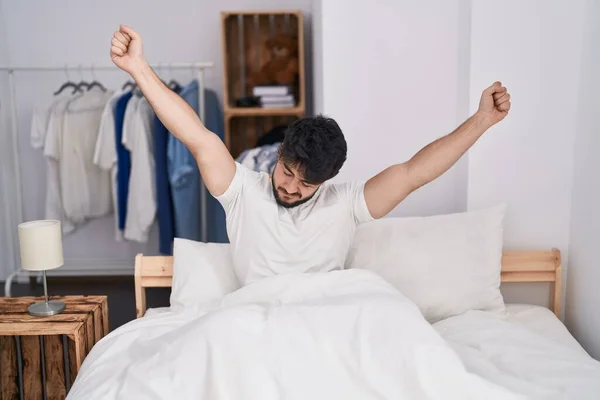 Young Hispanic Man Waking Stretching Arms Bedroom —  Fotos de Stock