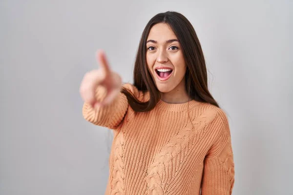 Genç Esmer Kadın Beyaz Arka Planda Dikiliyor Parmağıyla Işaret Ediyor — Stok fotoğraf