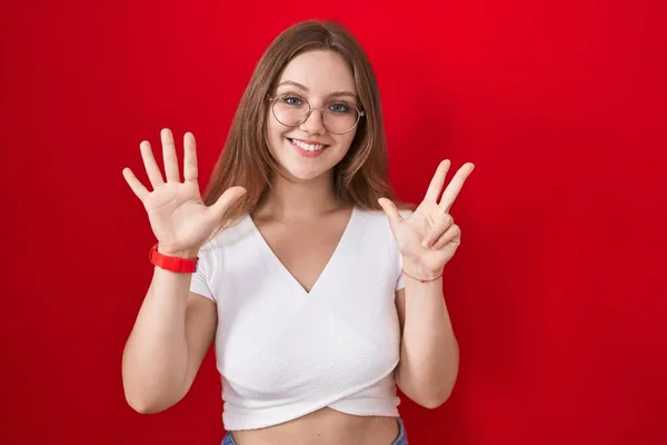 Młoda Kaukaska Kobieta Stojąca Nad Czerwonym Tle Pokazuje Wskazuje Palcem — Zdjęcie stockowe