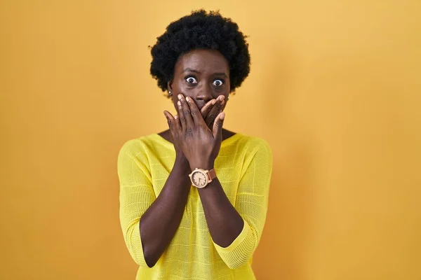 African Young Woman Standing Yellow Studio Shocked Covering Mouth Hands — Zdjęcie stockowe