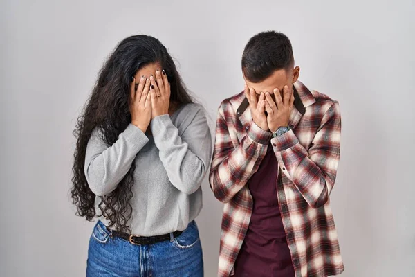 Young Hispanic Couple Standing White Background Sad Expression Covering Face — Stockfoto