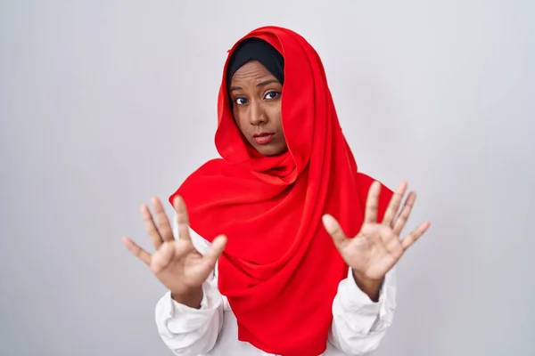 伝統的なイスラム教のヒジャーブスカーフを身に着けている若いアラブの女性は 恐怖と嫌な表情で拒否と否定を示す手のひらを離れて移動します 止めて禁止する — ストック写真