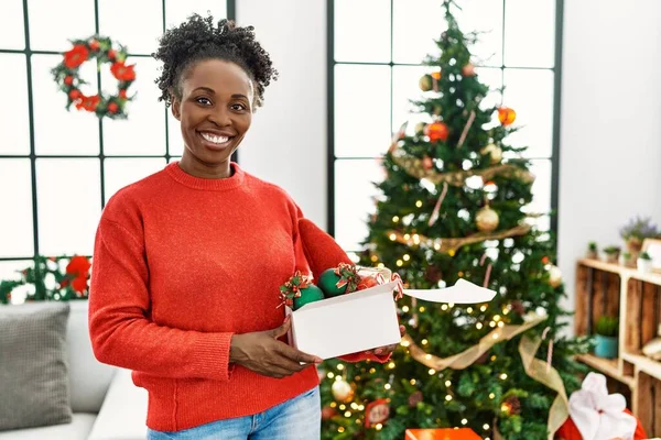 Afrikaans Amerikaanse Vrouw Glimlachen Zelfverzekerd Holding Kerst Decor Pakket Thuis — Stockfoto