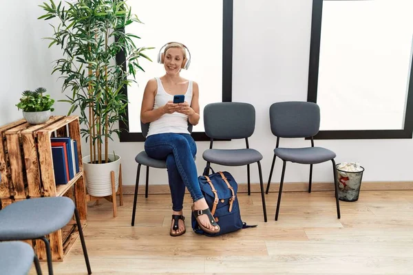 Mujer Joven Caucásica Usando Teléfono Inteligente Auriculares Sentados Silla Sala — Foto de Stock