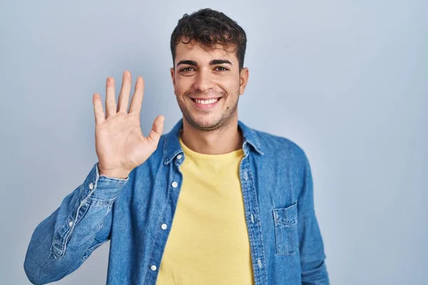 Young Hispanic Man Standing Blue Background Waiving Saying Hello Happy — Stock Photo, Image