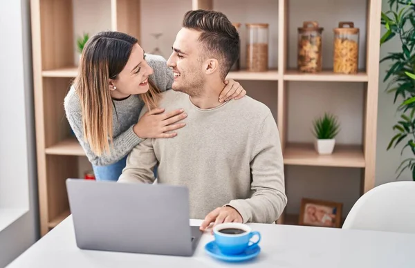男と女のカップル抱擁お互いに使用ノートパソコンでホーム — ストック写真