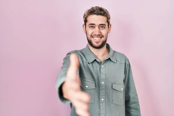 Hispanic Man Beard Standing Pink Background Smiling Friendly Offering Handshake — Stockfoto