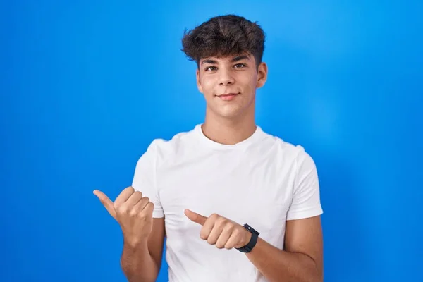 Іспанський Підліток Стоїть Над Синім Фоном Показуючи Спину Рукою Великим — стокове фото