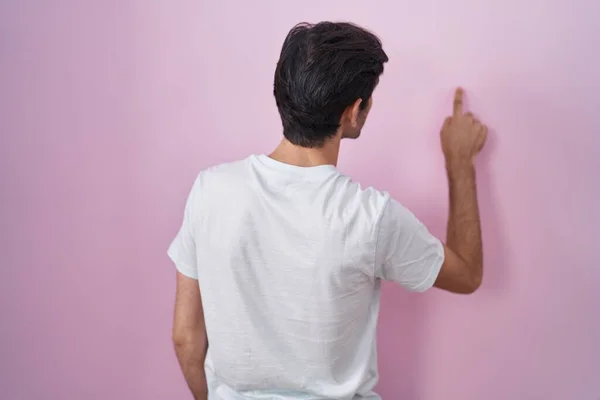 Young Hispanic Man Standing Pink Background Posing Backwards Pointing Ahead — Stok fotoğraf