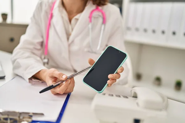 Young Caucasian Woman Wearing Doctor Uniform Showing Smartphone Screen Clinic — Stock Photo, Image