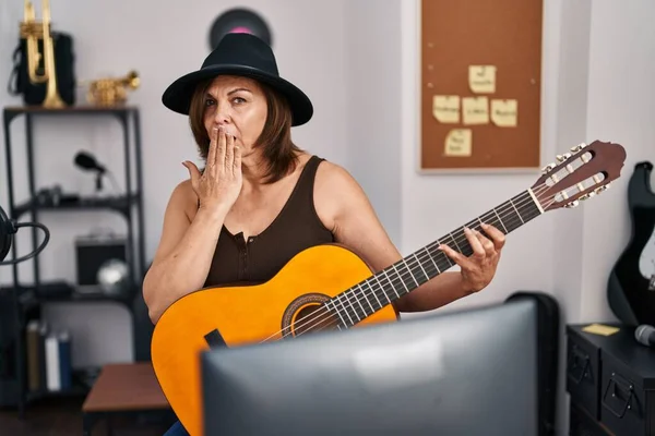 Латиноамериканка Средних Лет Играет Классической Гитаре Музыкальной Студии Прикрывая Рот — стоковое фото