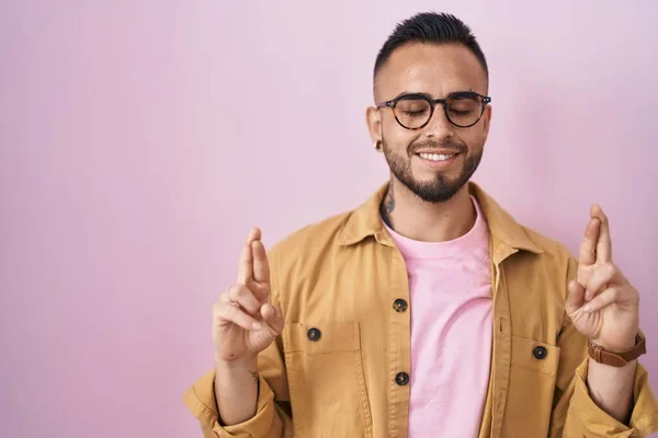Young Hispanic Man Standing Pink Background Gesturing Finger Crossed Smiling — Stock fotografie