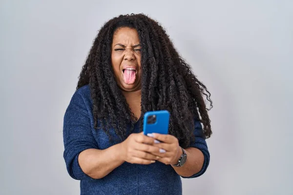 Size Hispanic Woman Using Smartphone Typing Message Sticking Tongue Out — Stockfoto