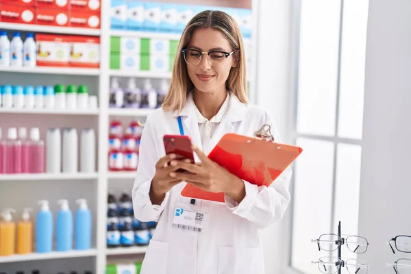 Giovane Farmacista Donna Bionda Utilizzando Smartphone Documento Lettura Farmacia — Foto Stock