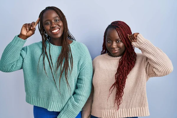 Twee Afrikaanse Vrouw Die Een Blauwe Achtergrond Staat Glimlachen Wijzend — Stockfoto