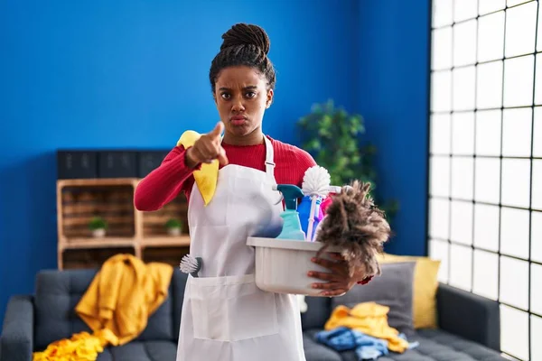 Joven Afroamericano Con Trenzas Limpiando Casa Sosteniendo Productos Limpieza Apuntando —  Fotos de Stock