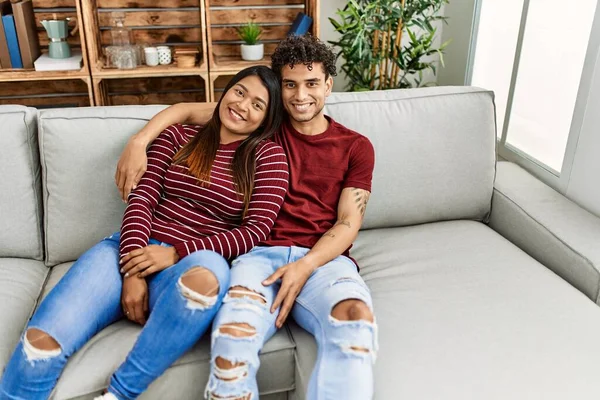 Молода Латинська Пара Посміхається Щаслива Обіймається Сидячи Дивані Вдома — стокове фото