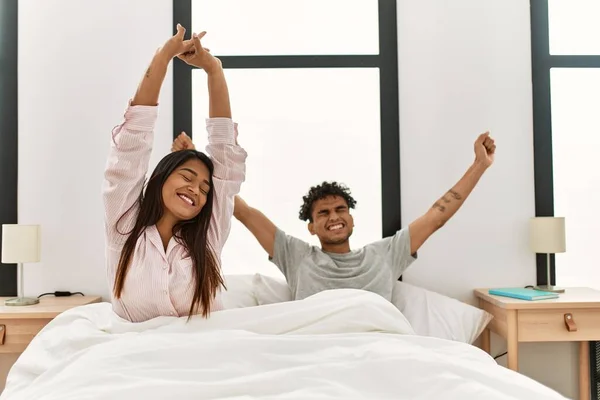 Unga Latinska Par Gäspar Och Sträcker Armarna Liggande Sängen Sovrummet — Stockfoto