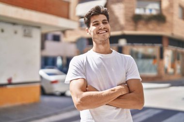 Parkta kollarını kavuşturmuş İspanyol genç bir adam.