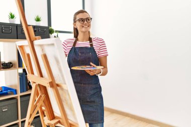 Sanat stüdyosunda kendine güvenen genç bir kadın.