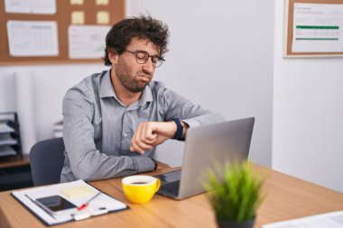 Genç İspanyol iş adamı. Ofise bakmak için dizüstü bilgisayar kullanıyor.