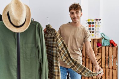 Giysi dükkanından kendine güvenen, gülümseyen beyaz bir adam.