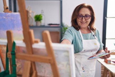 Senior woman artist smiling confident drawing at art studio
