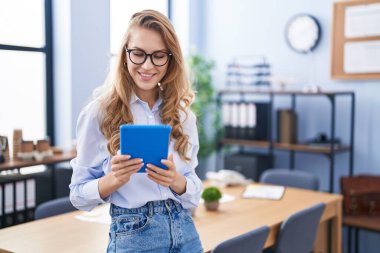 Ofiste dokunmatik ped kullanan genç sarışın bir iş kadını.