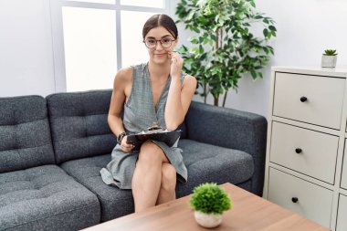 Psikoloji kliniğinde çalışan genç İspanyol kadın ağzı ve dudakları parmaklarla kapanmış. gizli ve sessiz, tabu konuşması 