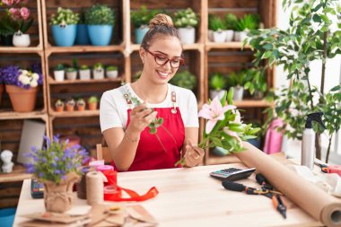 Çiçekçide çiçek buketi yapan güzel İspanyol kadın.