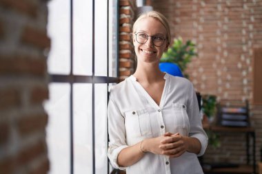Young blonde woman business worker smiling confident standing at office