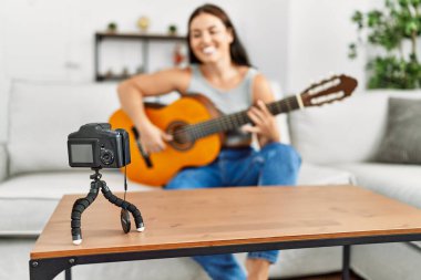 Evinde klasik gitar çalan genç ve güzel bir İspanyol kadın.