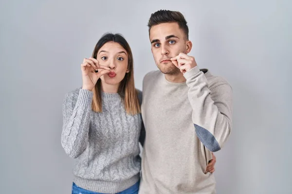 Young Hispanic Couple Standing White Background Mouth Lips Shut Zip — Stockfoto