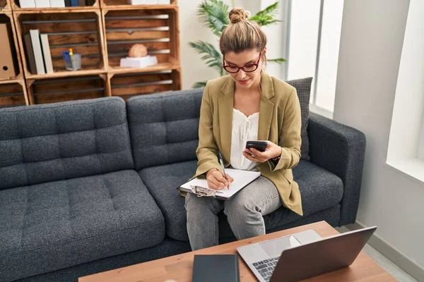 Young Blonde Woman Psychologist Using Smartphone Sitting Sofa Psychology Center — Stock Photo, Image