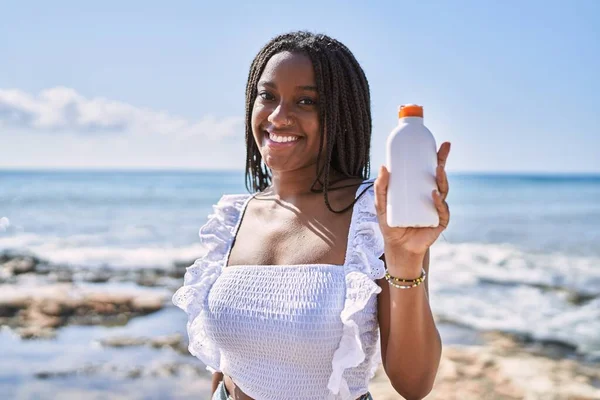 Ung Afrikansk Amerikansk Flicka Ler Glad Hålla Solkräm Lotion Stranden — Stockfoto
