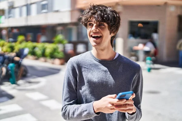 Jonge Spaanse Man Glimlacht Vol Vertrouwen Met Behulp Van Smartphone — Stockfoto