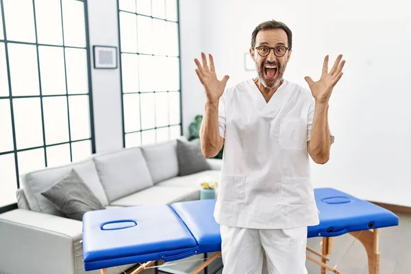 Orta Yaşlı Fizyoterapist Zaferi Mutlu Bir Gülümseme Ellerini Kaldırarak Kutluyor — Stok fotoğraf