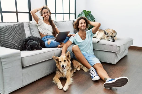 Jovem Casal Hispânico Com Cães Relaxantes Casa Sorrindo Confiante Tocando — Fotografia de Stock