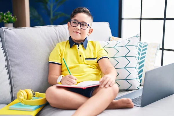 Genç Spanyol Çocuk Ödev Yapıyor Kanepede Oturuyor Gülümsüyor Yan Bakıyor — Stok fotoğraf