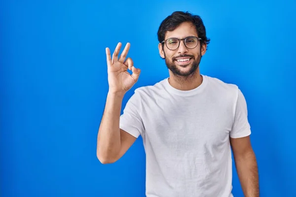 Handsome Latin Man Standing Blue Background Smiling Positive Doing Sign — Stockfoto