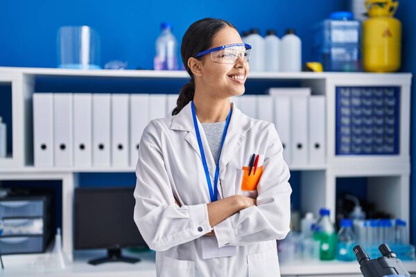 Young african american woman scientist standing with arms crossed gesture at laboratory