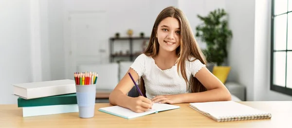 Liebenswertes Mädchen Macht Hausaufgaben Hause Auf Dem Tisch Sitzend — Stockfoto