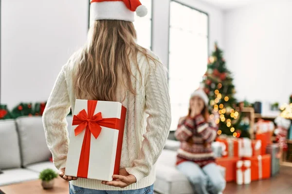 Γυναίκα Ζευγάρι Έκπληξη Δώρο Στην Πλάτη Κάθεται Από Χριστουγεννιάτικο Δέντρο — Φωτογραφία Αρχείου