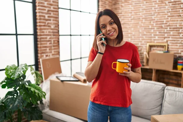 Young Beautiful Hispanic Woman Talking Smartphone Drinking Coffee New Home — Fotografia de Stock