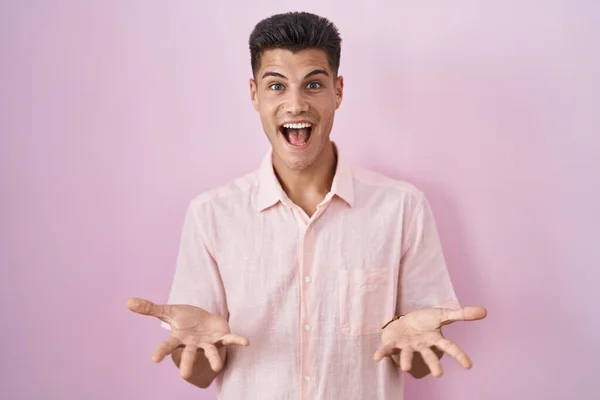 Νεαρός Ισπανόφωνος Στέκεται Πάνω Από Ροζ Φόντο Χαμογελώντας Χαρούμενα Ανοιχτές — Φωτογραφία Αρχείου