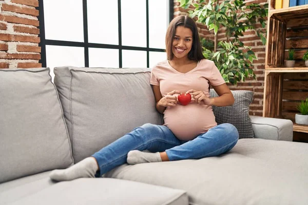 Mujer Latina Joven Embarazada Sosteniendo Corazón Sentado Sofá Casa — Foto de Stock