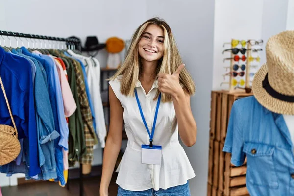 年轻的金发女人在零售精品店当经理 手举着快乐的大拇指做手势 赞成的表情看着相机显示的成功 — 图库照片