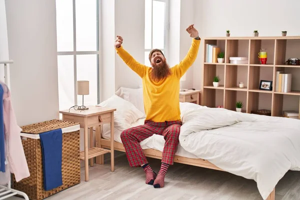 Stock image Young redhead man waking up stretching arms yawning at bedroom